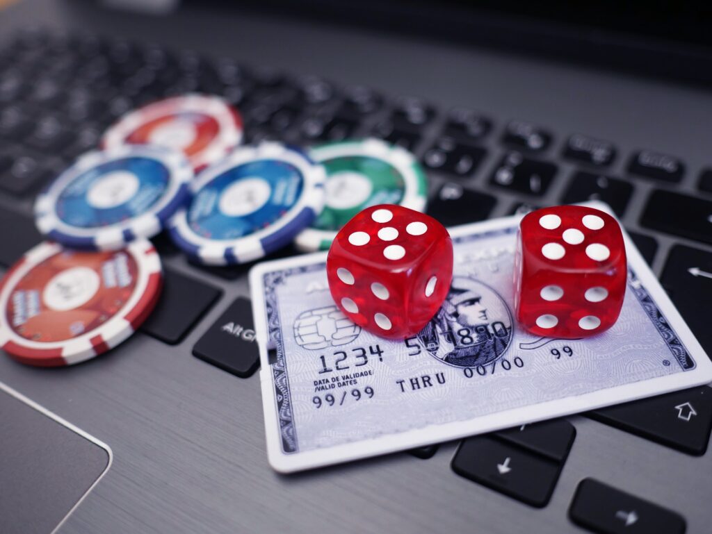 online casino agency  credit card and dice on laptop with poker chips